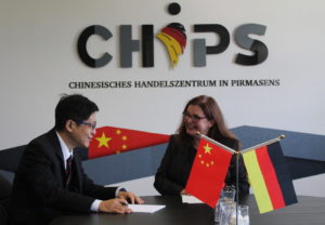 Eine Frau und ein mann am Tisch mit chinesischer und deutscher Flagge